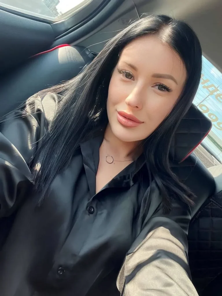 beautiful brunette woman taking car selfie with straight black hair and natural makeup