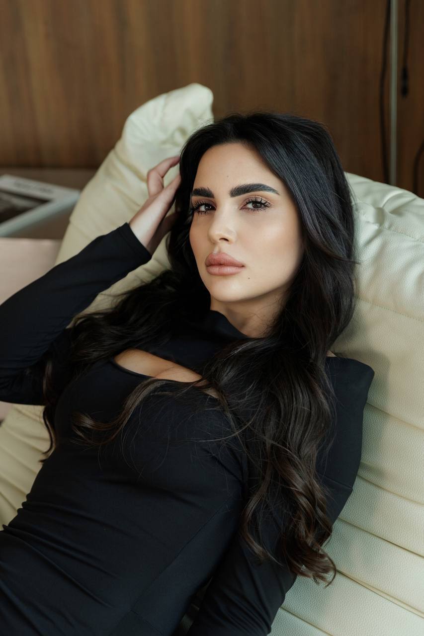 Close-up portrait of an elegant brunette luxury escort model with natural makeup and long dark hair