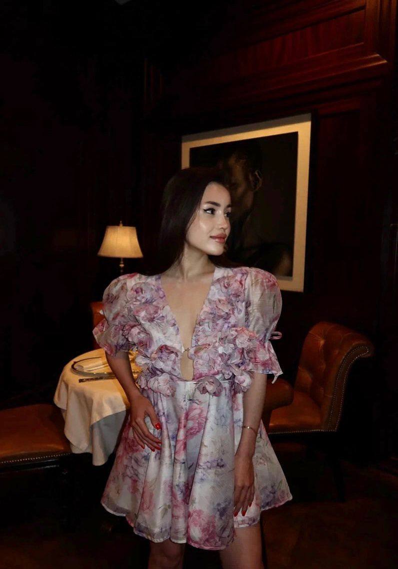 Elegant Asian fashion model wearing a floral mini dress inside a luxury fine dining restaurant.
