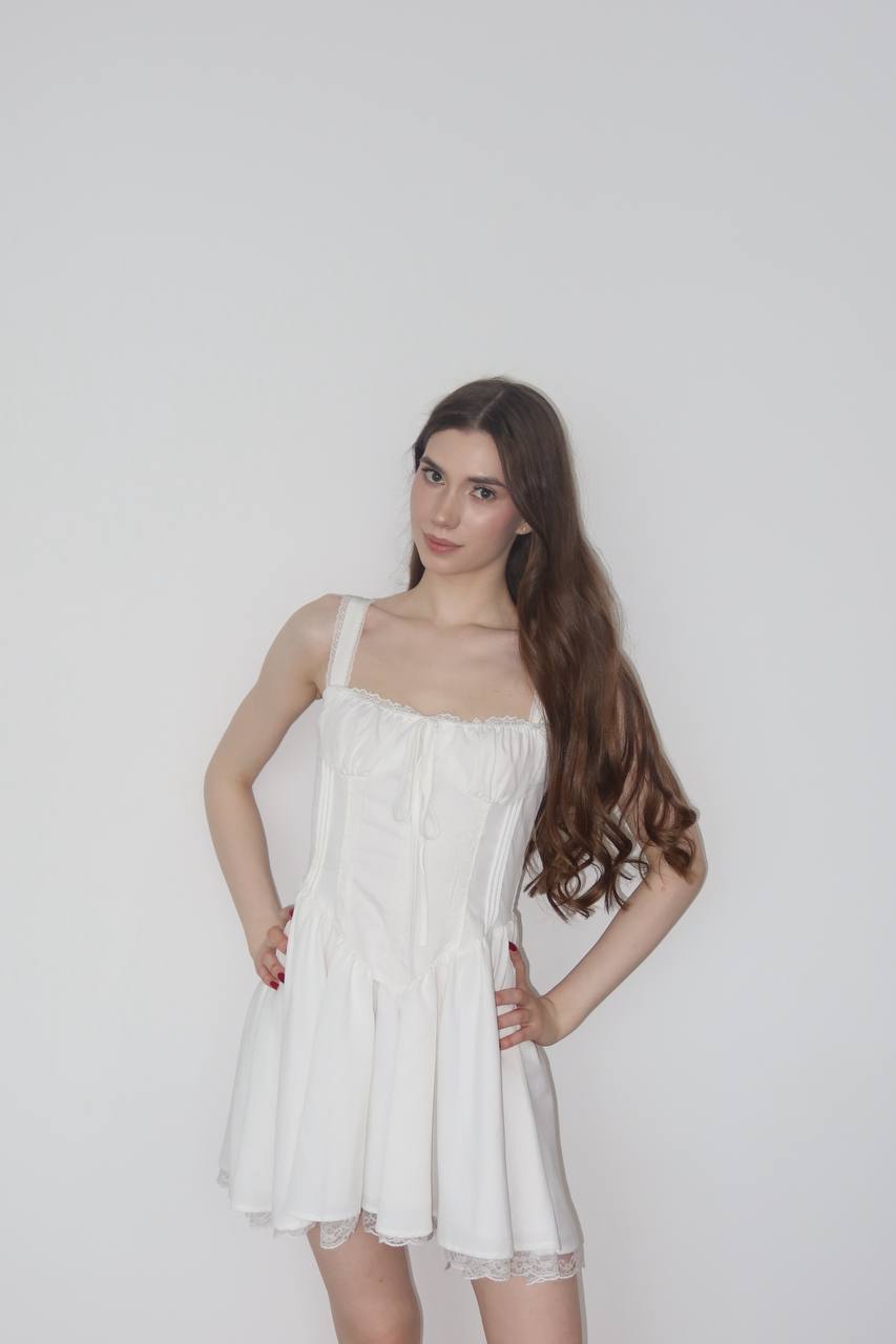 Ultra realistic full body portrait of a young brunette woman with long silky dark brown hair wearing an elegant white corset dress in a clean studio, luxury fashion editorial, soft natural lighting, photorealistic.