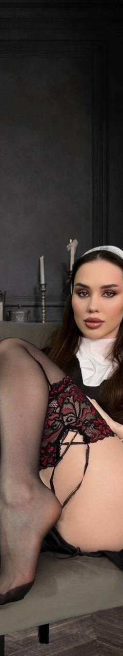 Brunette woman in elegant lingerie and sheer stockings posing on a chair in a luxurious classic interior