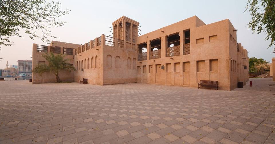 Traditional sand-colored heritage house with wind towers in Al Fahidi historical district, Dubai