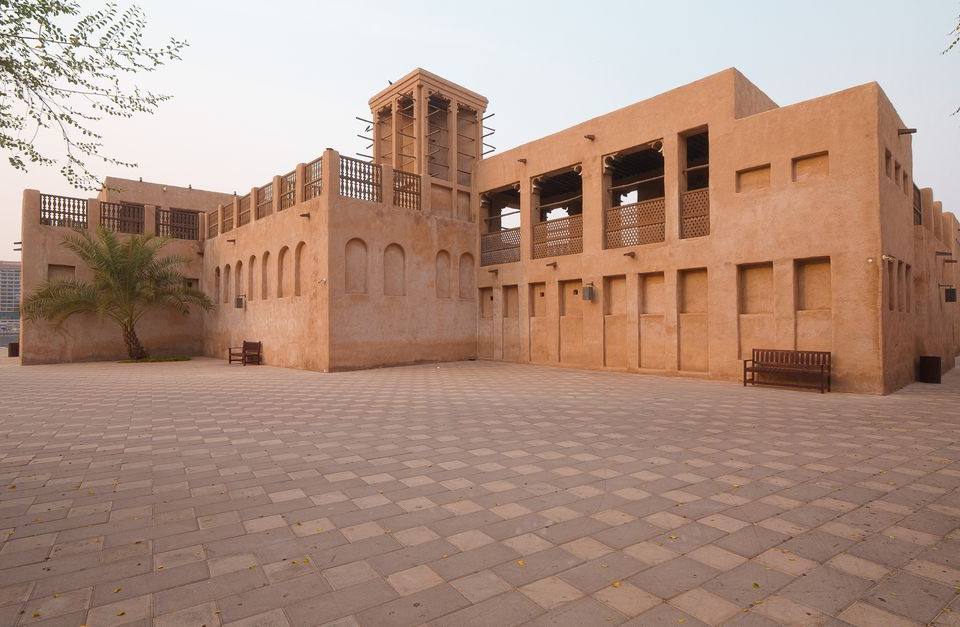 Traditional sand-colored heritage house with wind towers in Al Fahidi historical district, Dubai